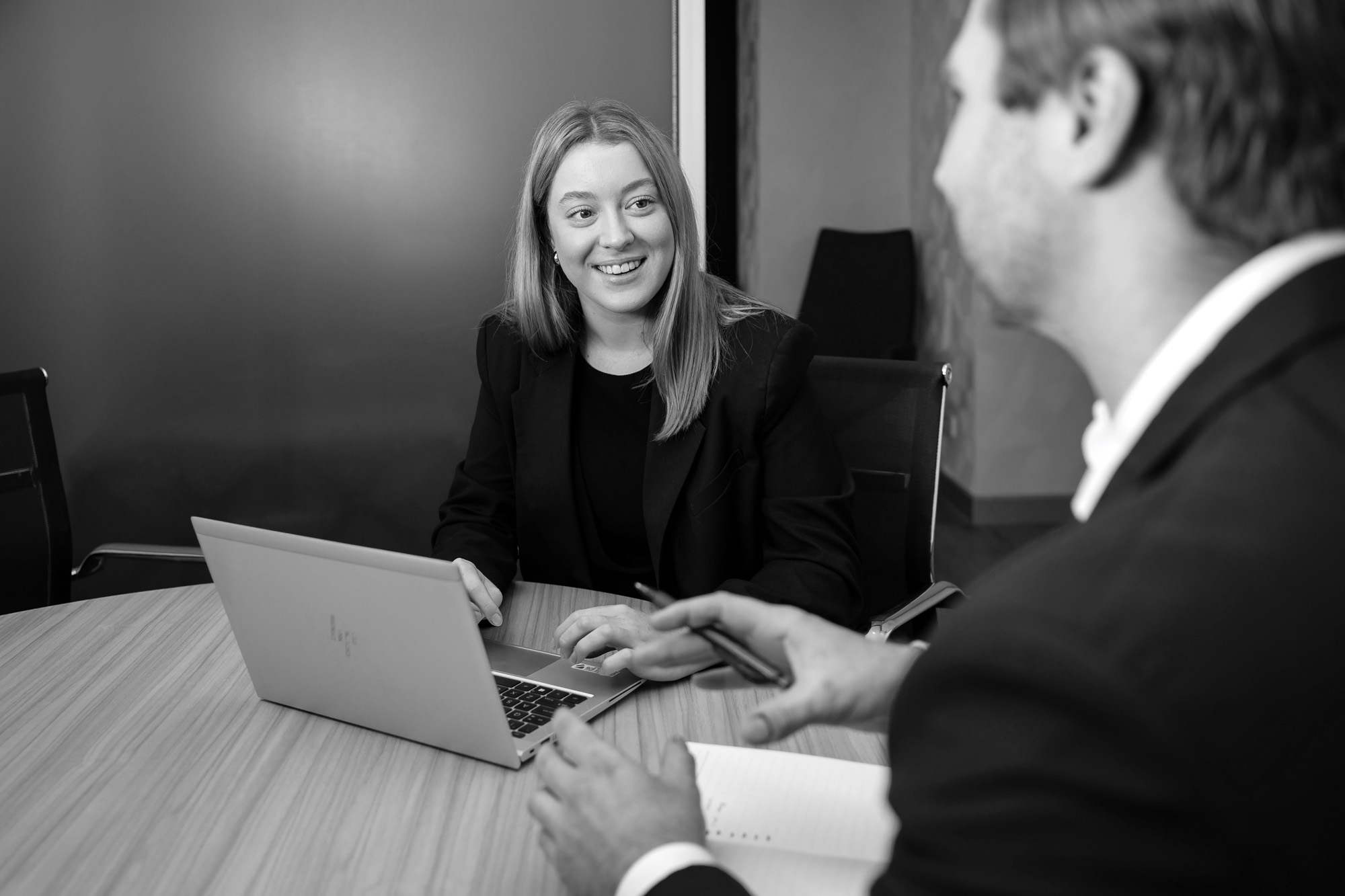 Girl smiling at coworker with laptop
